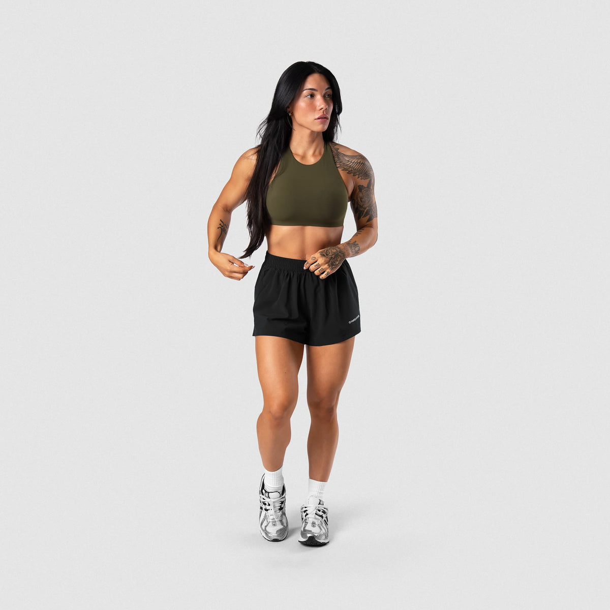 Female model wearing the Axis High Neck Bra - OD Green full-body view