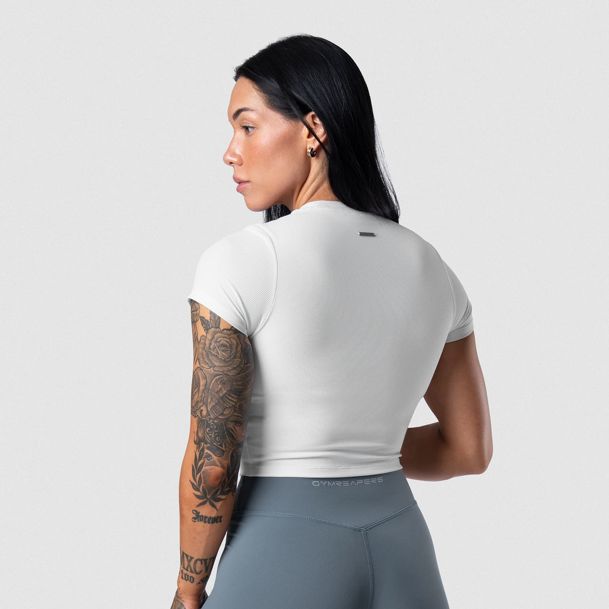 Female model wearing the Axis Support Baby Tee - White back view