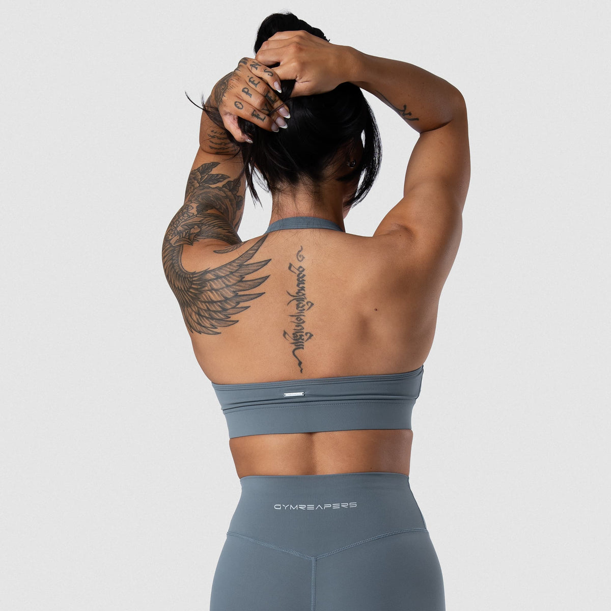 Female model wearing the Axis Twisted Halter Bra - Lake back view