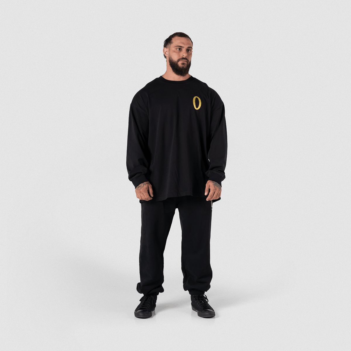Man in black hoodie and matching pants, side/back three-quarter view, full body