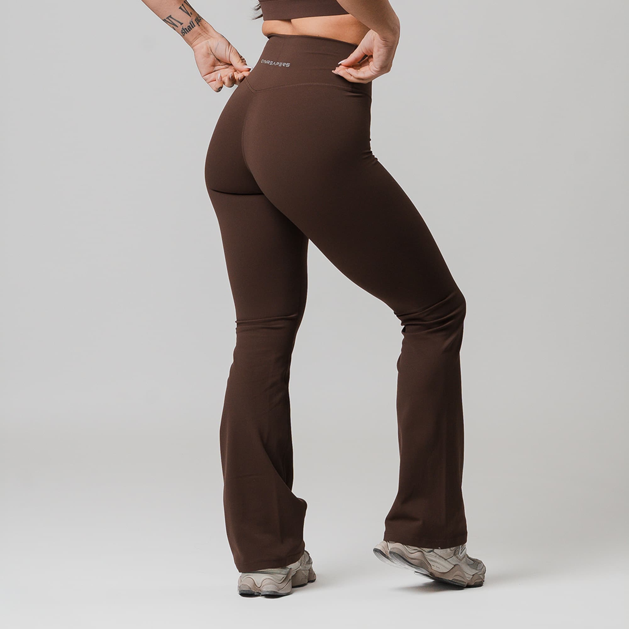 athlete wearing brown axis flare leggings half body shot back view