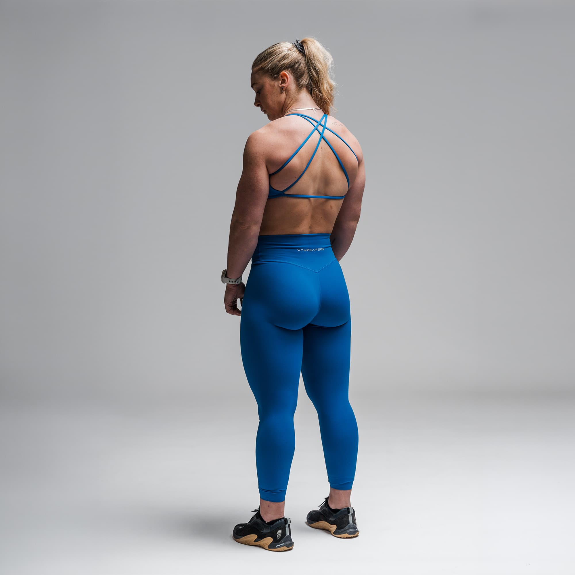 Athlete wearing the Electric Blue Axis Open Back Bra full body shot back view