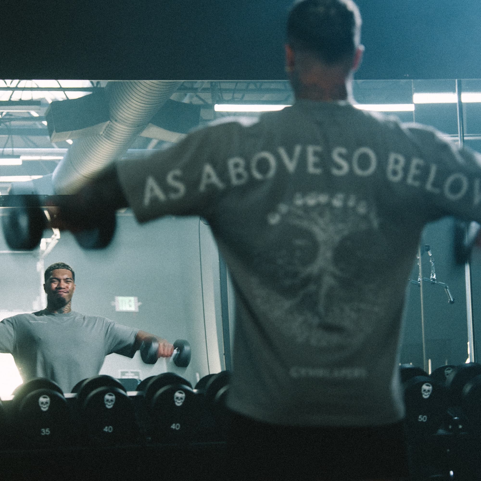 Lifestyle image of athlete mid-workout in the Reflection Graphic Tee, with the back graphic in full view.