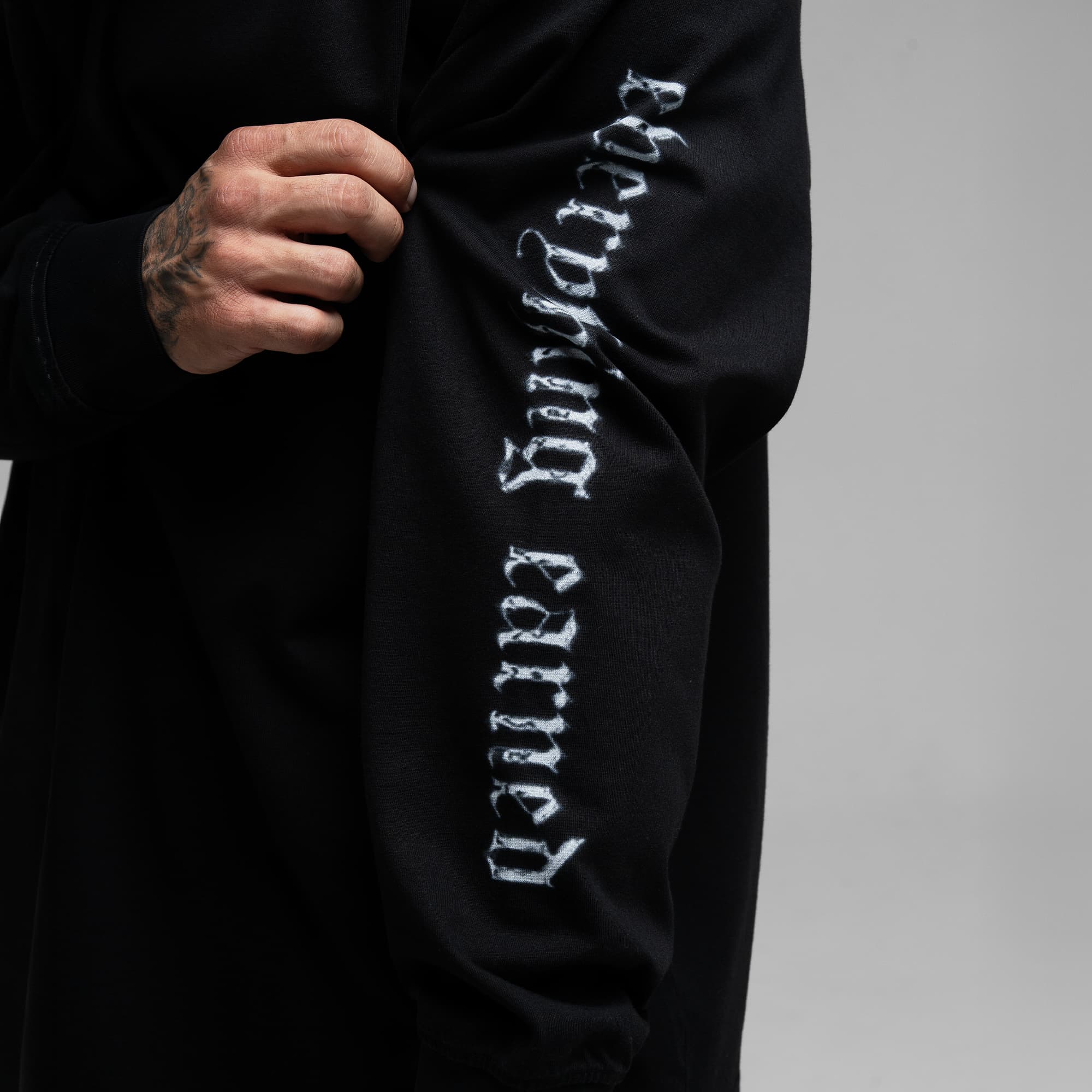Athlete wearing Chrome Legacy Long Sleeve Shirt close up shot of "everything earned" sleeve graphic