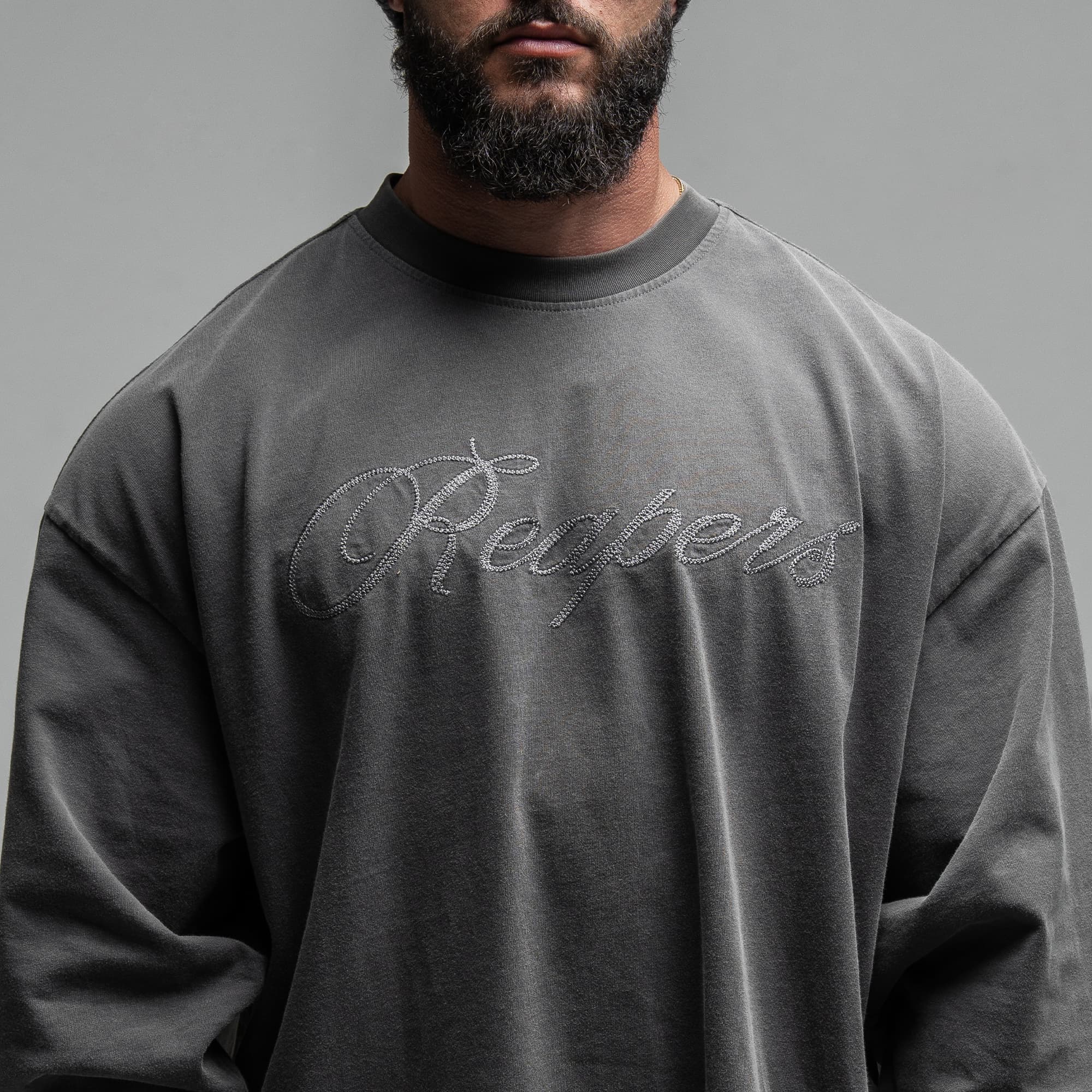 Athlete wearing Reaper Chainscript Long Sleeve Shirt close up shot of front logo