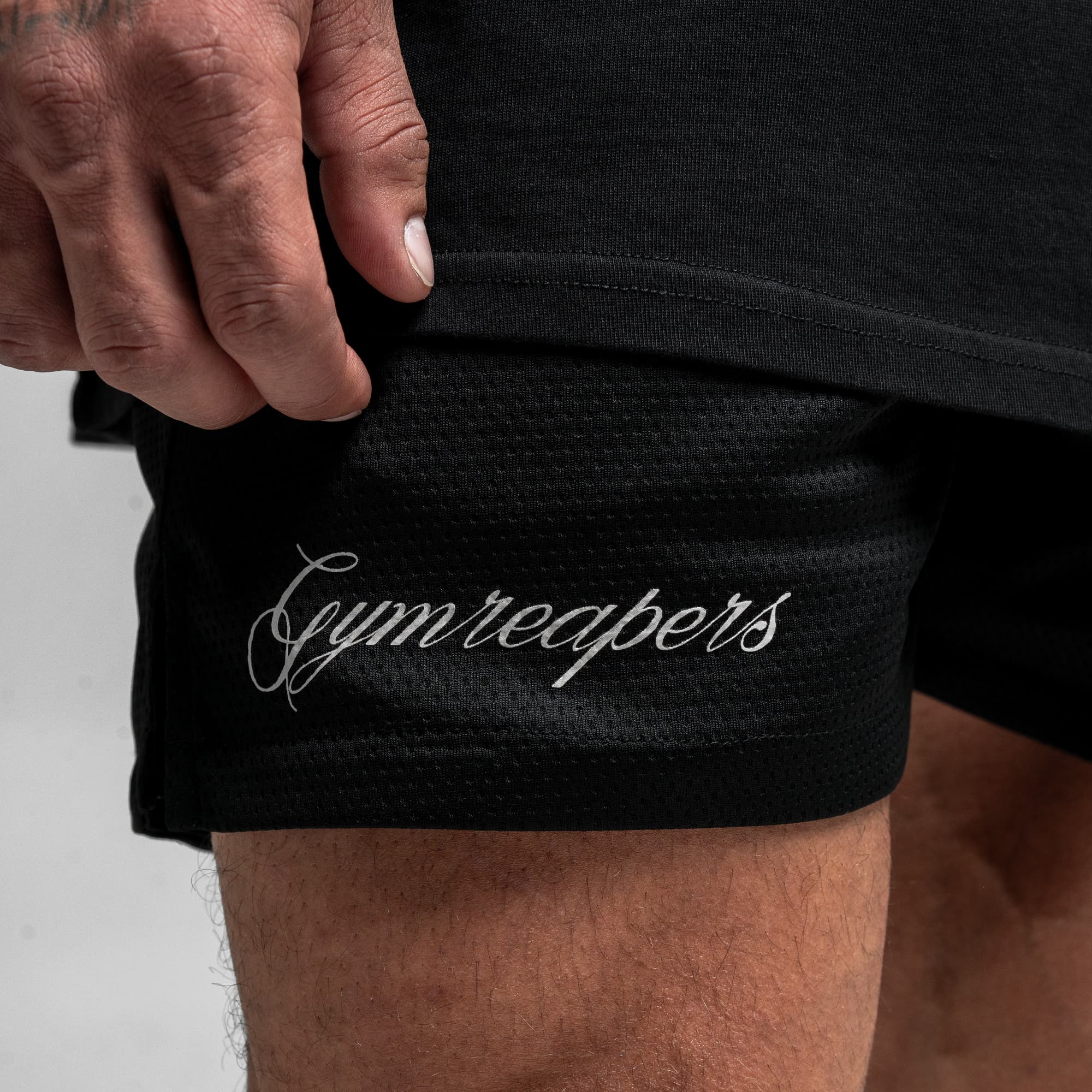 Athlete wearing Reaper Script Mesh Shorts close up shot of gymreapers logo