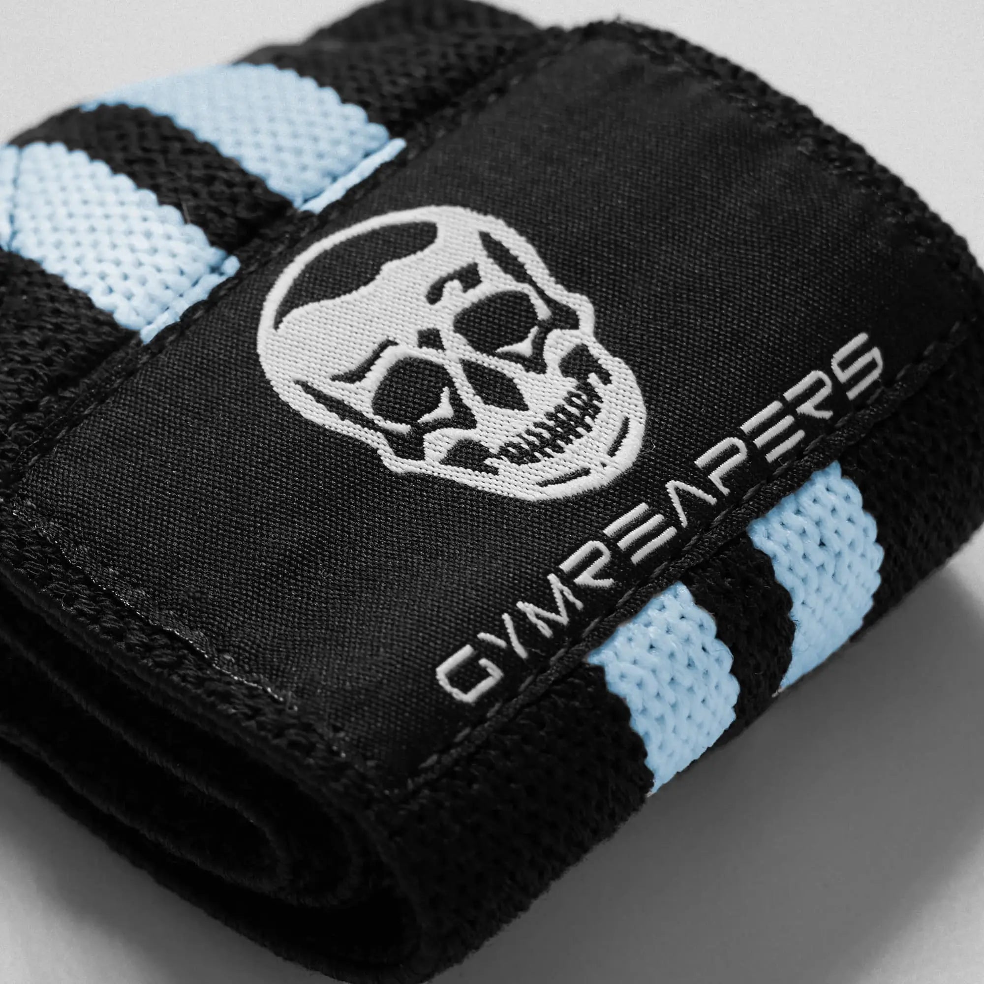 Close up shot of black wrist wraps with blue accents on gray background