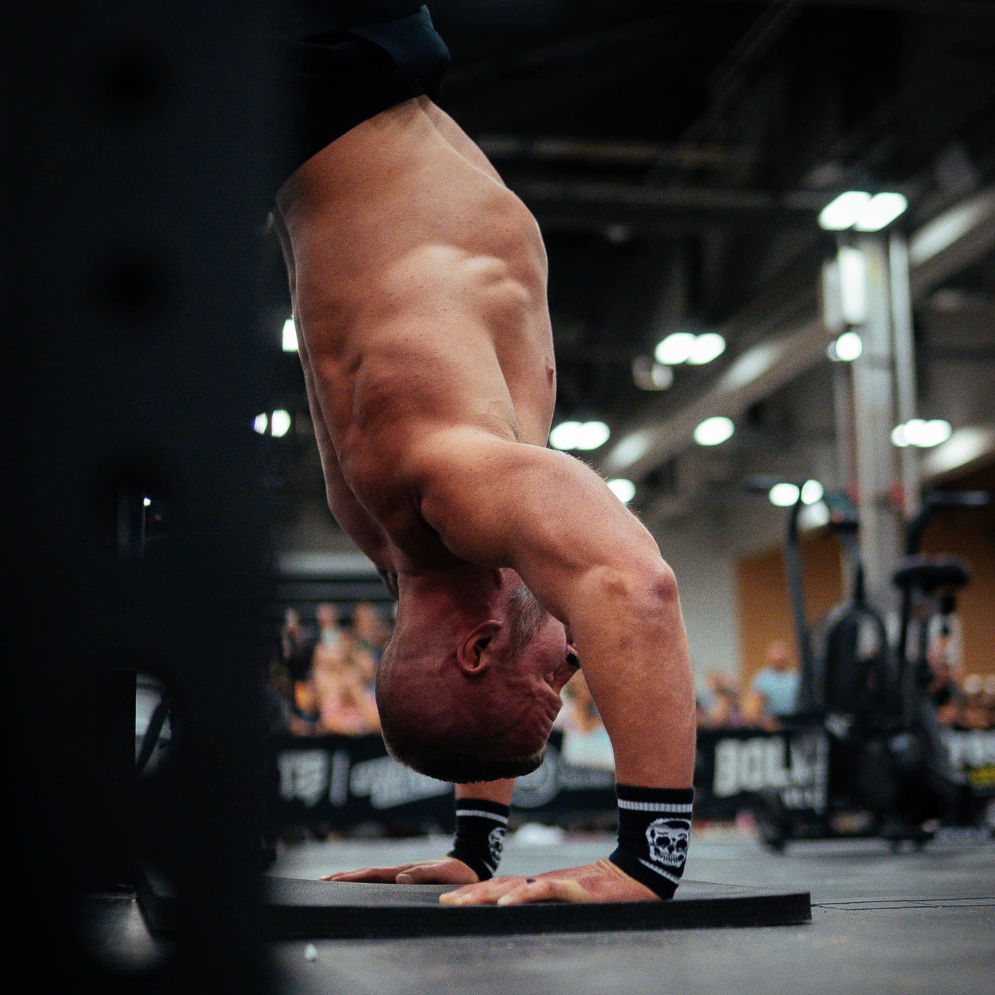 athlete doing a handstand with skull wrist bands on