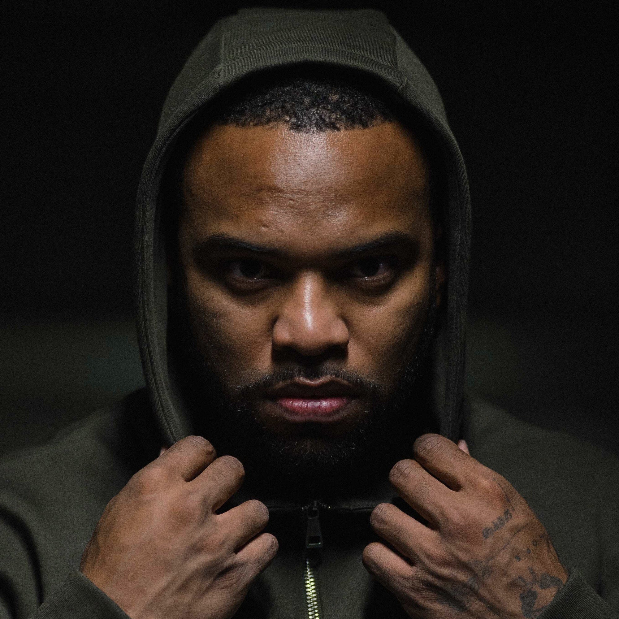 axis zip up od green athlete having hoodie over head.