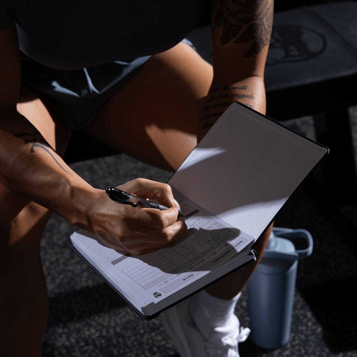 Women's Workout Journal in Black – Lifestyle, Open Page Flat Lay