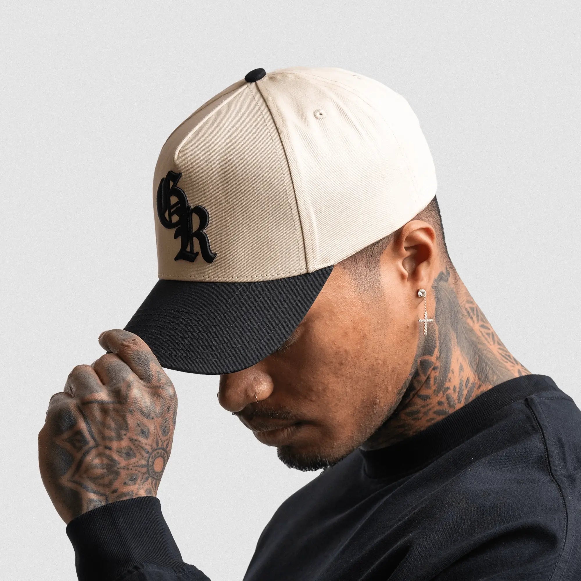 5 panel initial hat cream black on athlete studio gray background left side shot