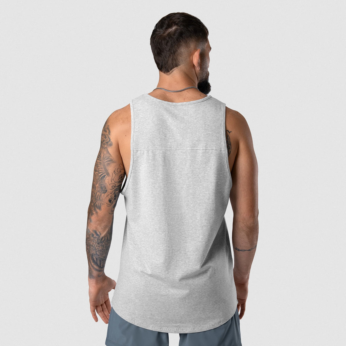Male model wearing the Axis Scoop Hem Tank - Heather Gray back view
