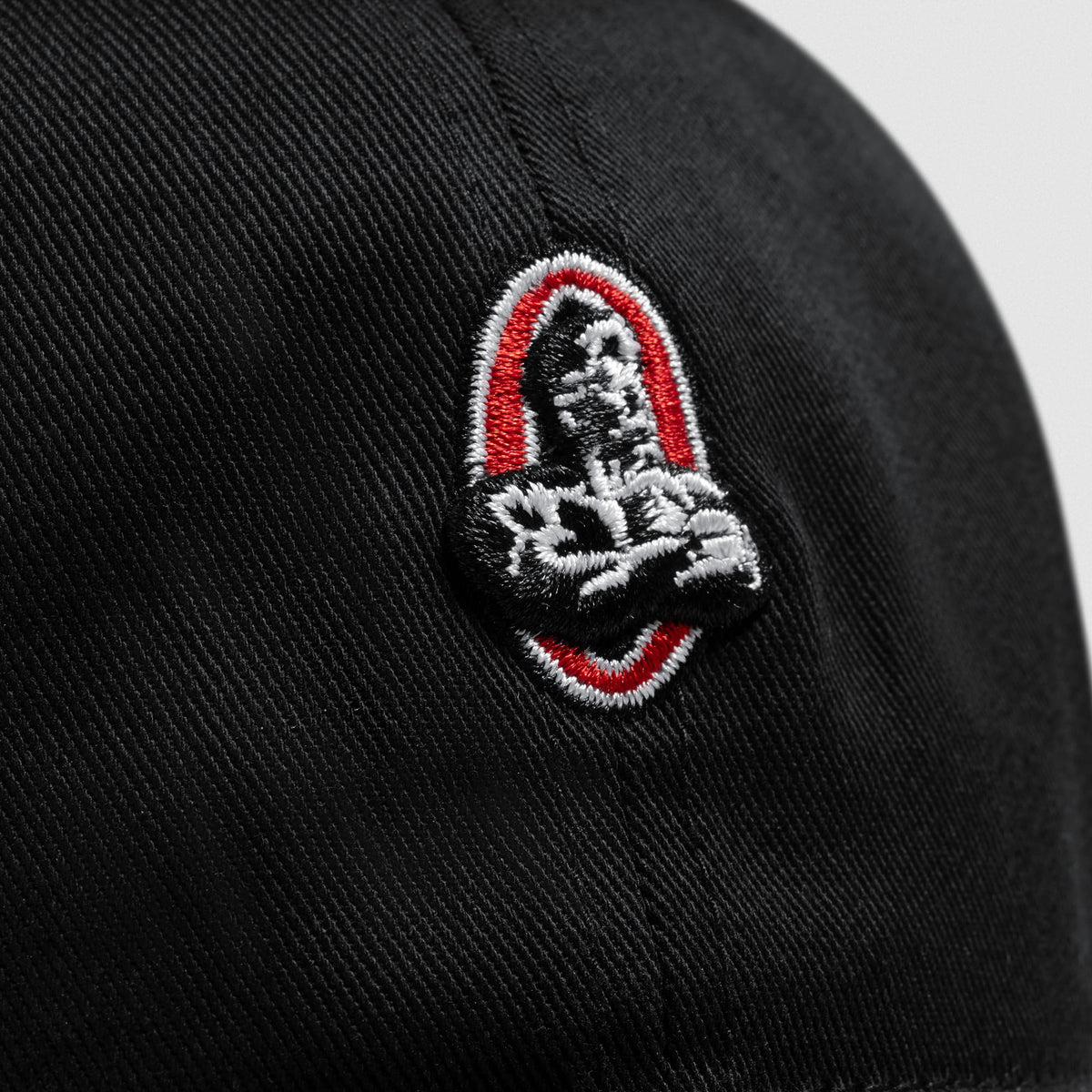 Close up of the small signature olympia bodybuilding logo on the Micro Joe Dad Hat