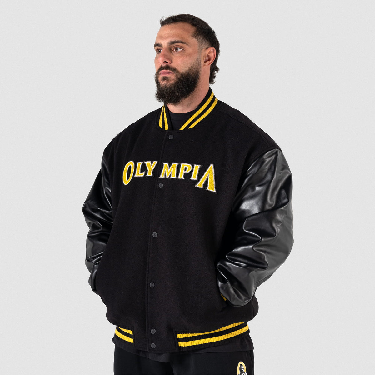 Olympia Champions Gold Varsity Jacket in Black – On Model, Front View
