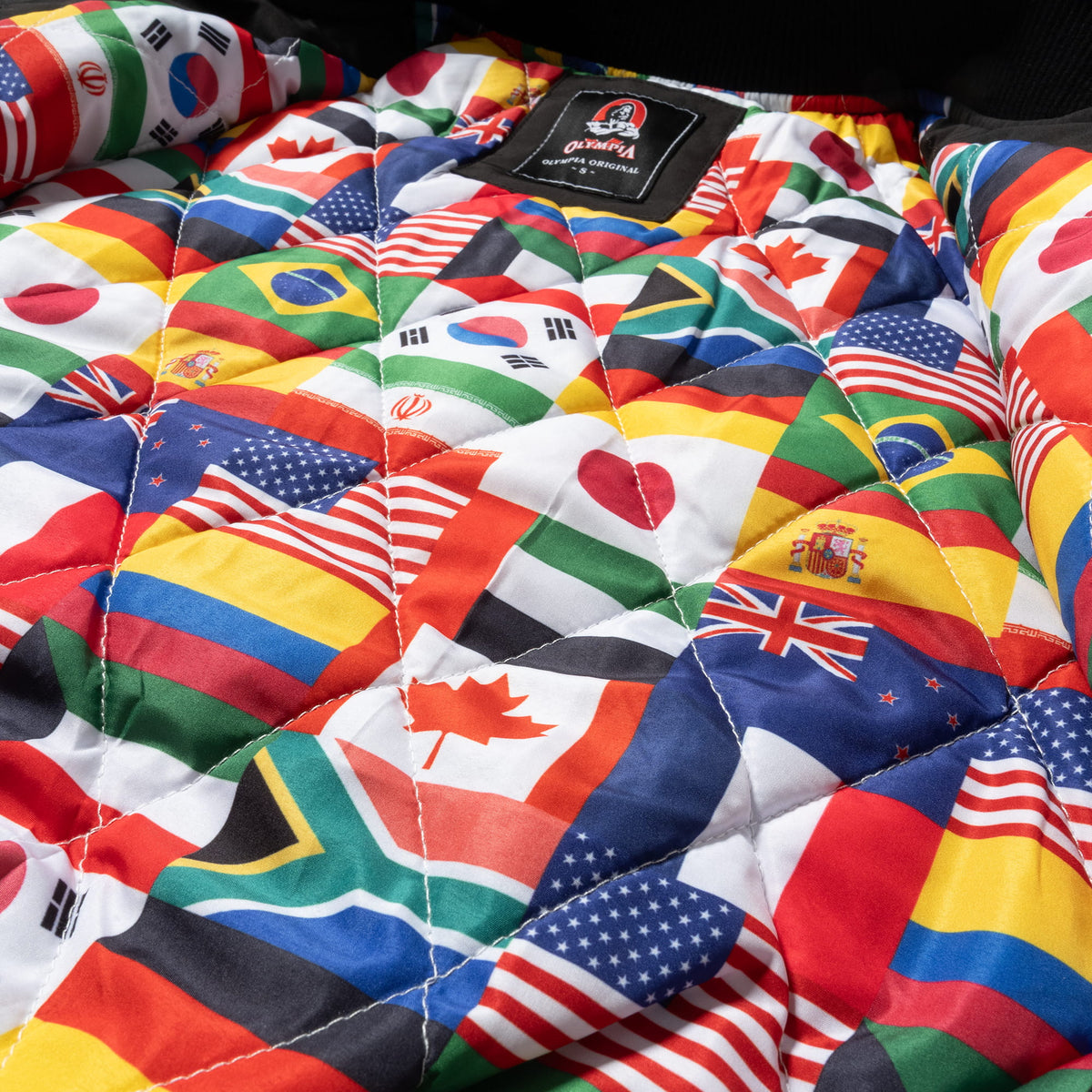 International Division Crop Bomber Jacket | Internal quilt of the worldwide flags that make up the Olympia International Division