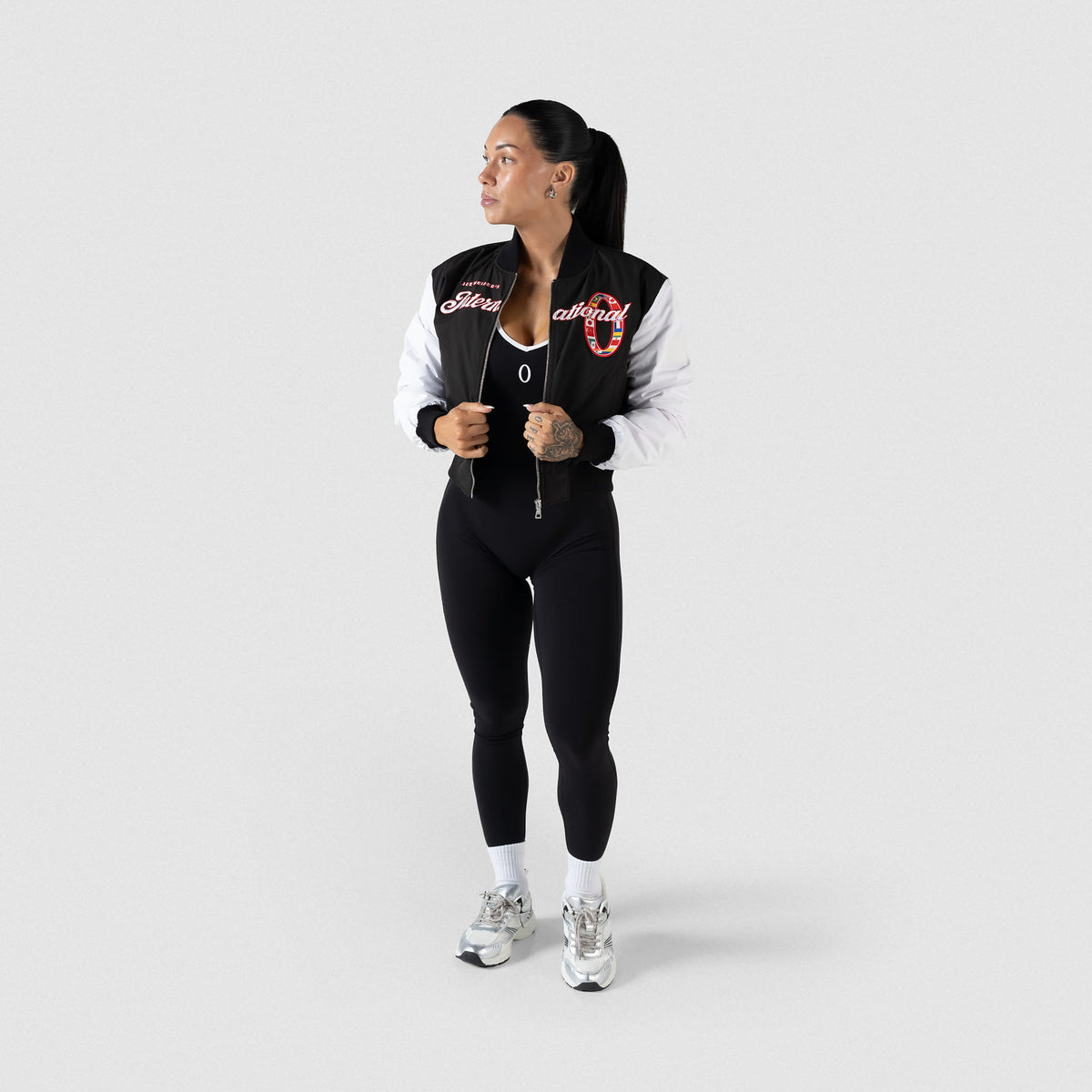 International Division Crop Bomber Jacket | Full body model view of the black and white jacket paired with Olympia Leggings