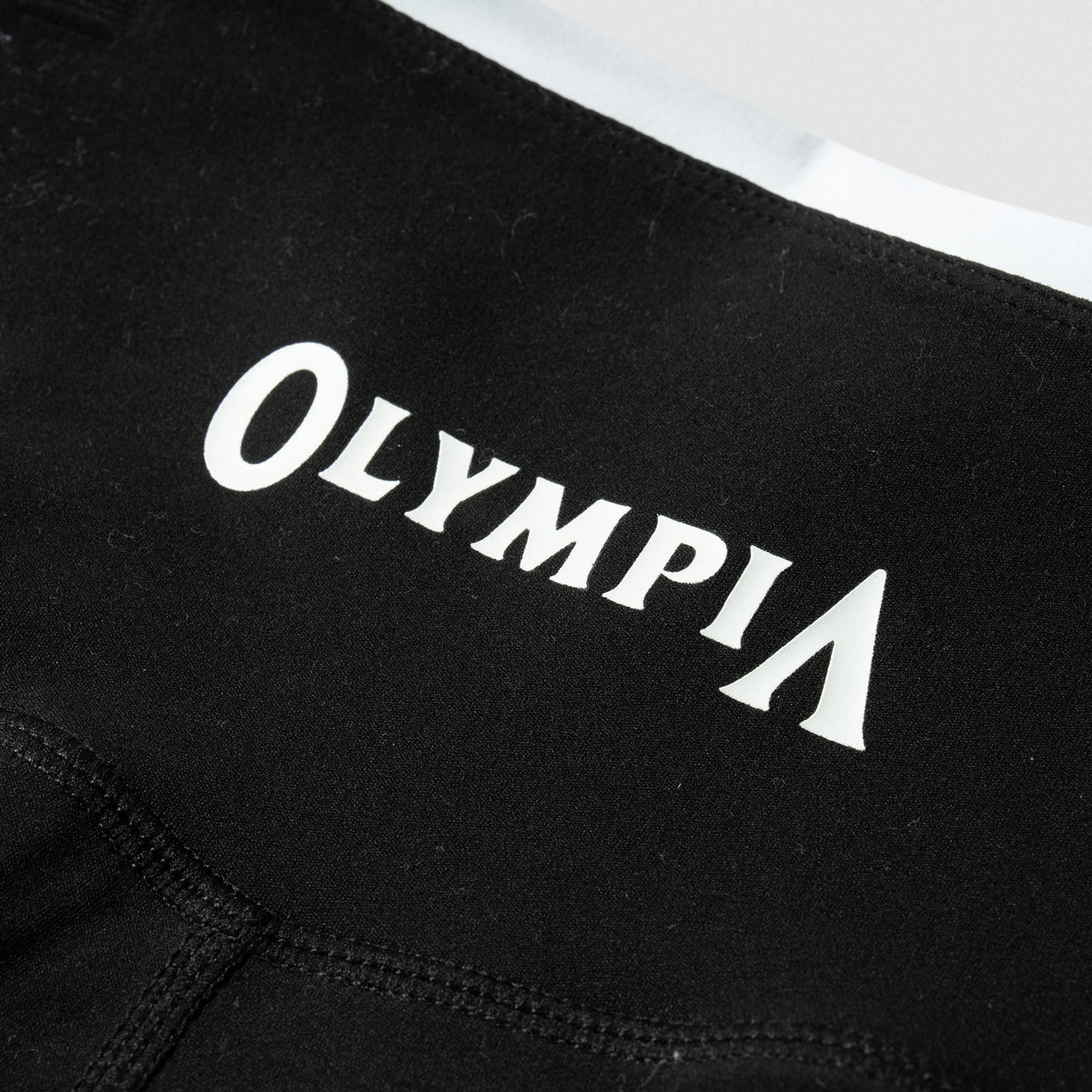 White "Olympia" wordmark logo on the back of the Women's Olympia Legging in black