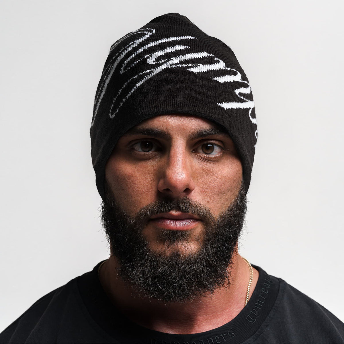 Front facing image of model wearing the black Olympia Script Skull Cap with white Olympia text 