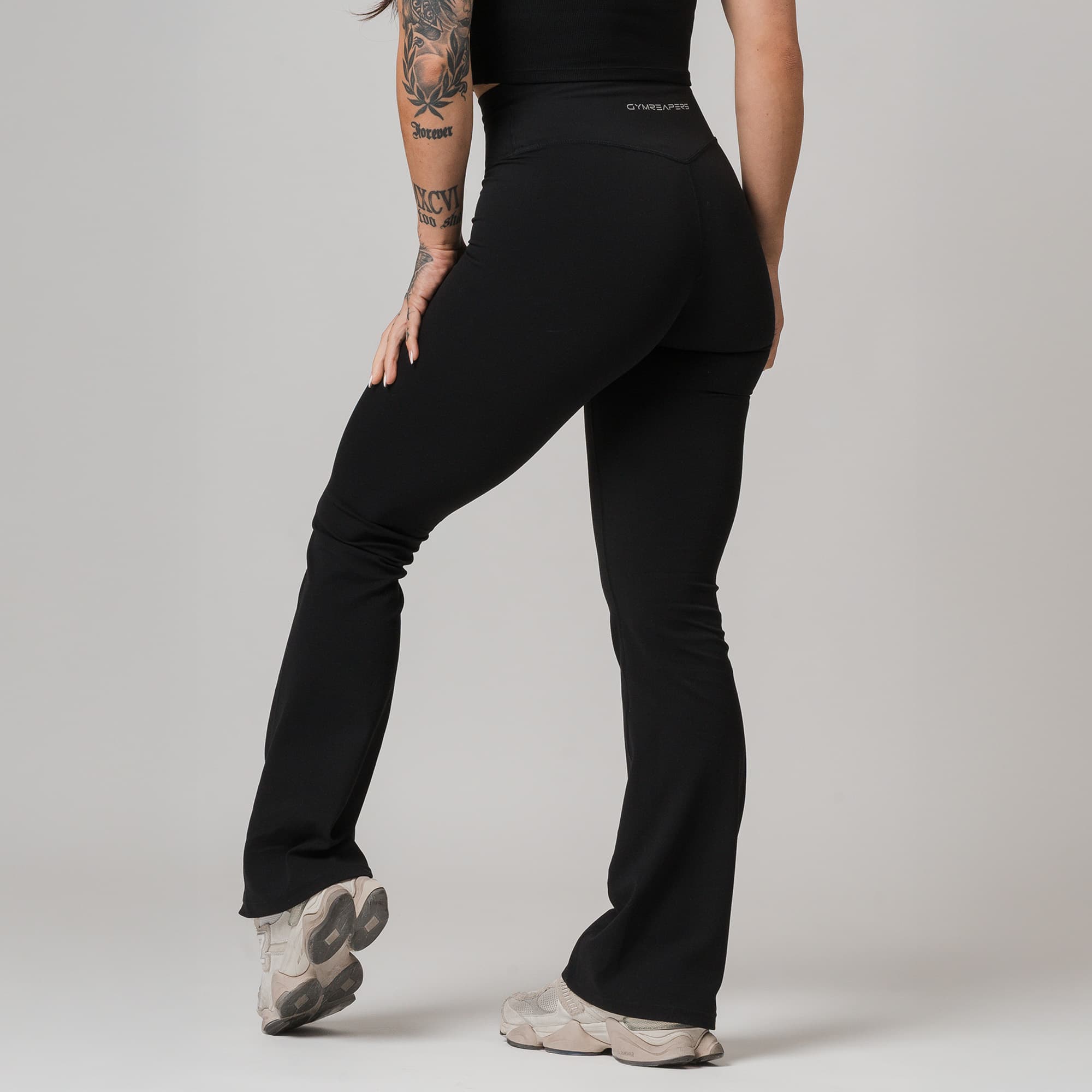 athlete wearing black axis flare leggings half body shot back view
