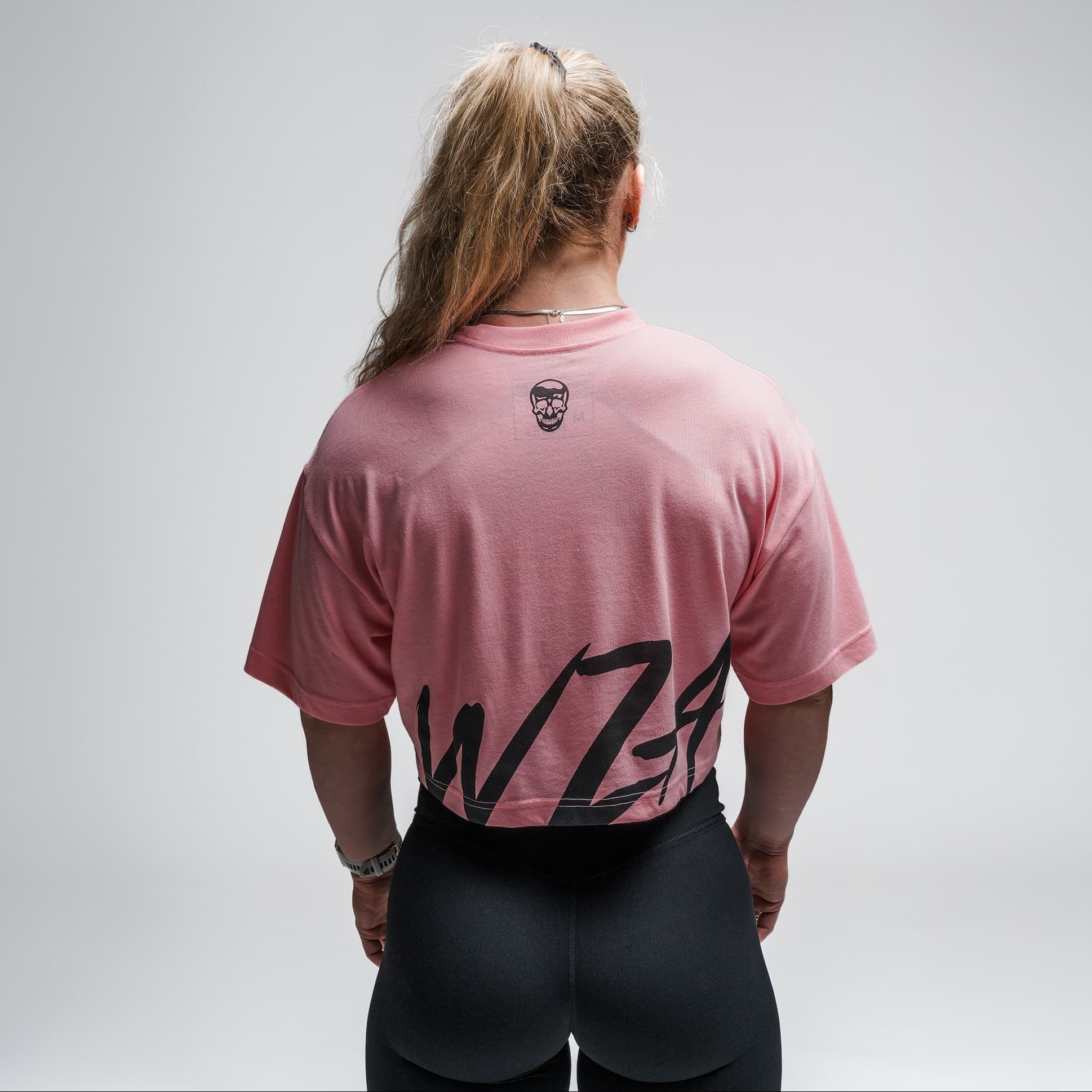 Athlete wearing the Pink Heatstroke Cropped Tee half body shot back view