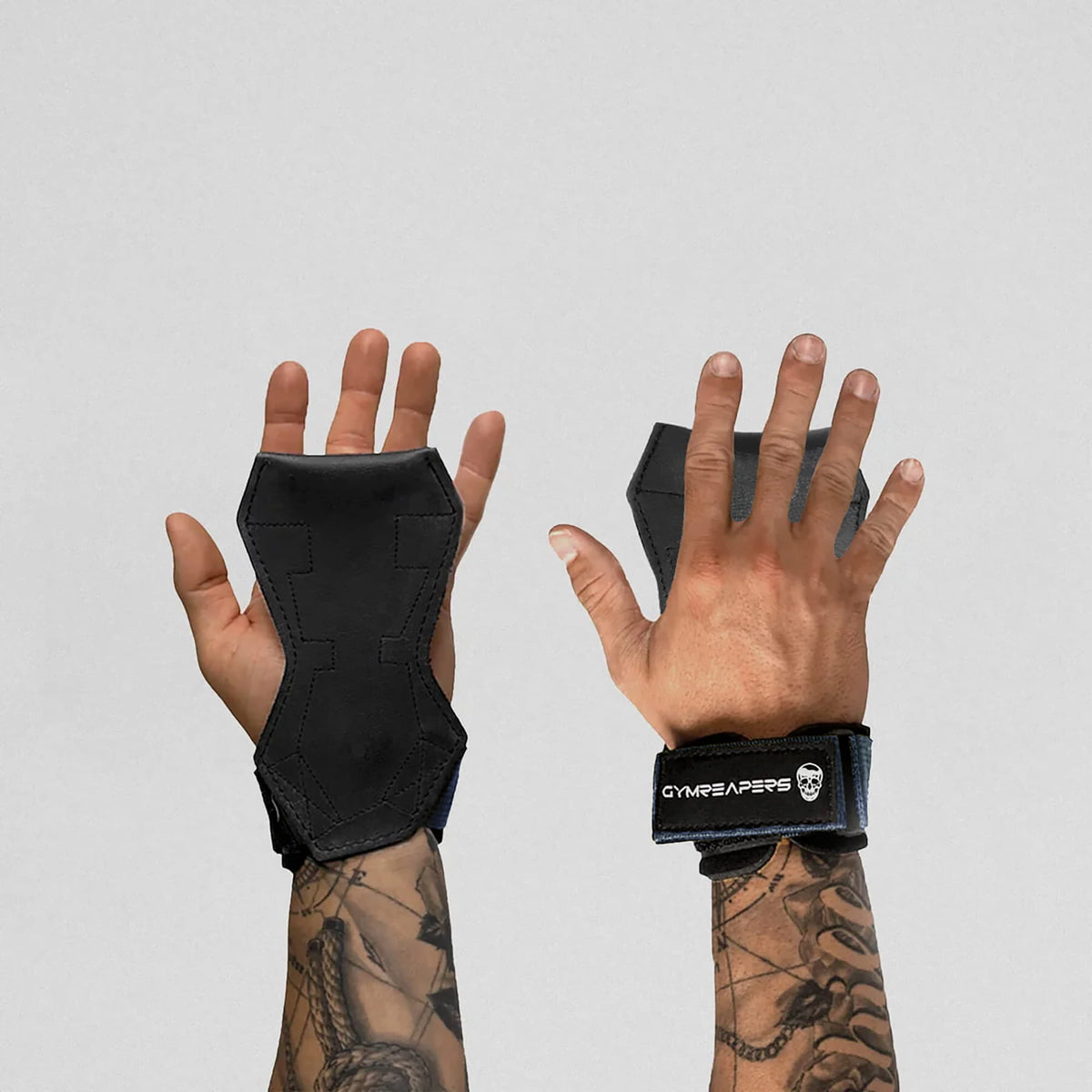 Gymreapers lifting grips navy on hands, one hand facing down and the other facing up to showcase both ends of the grips.