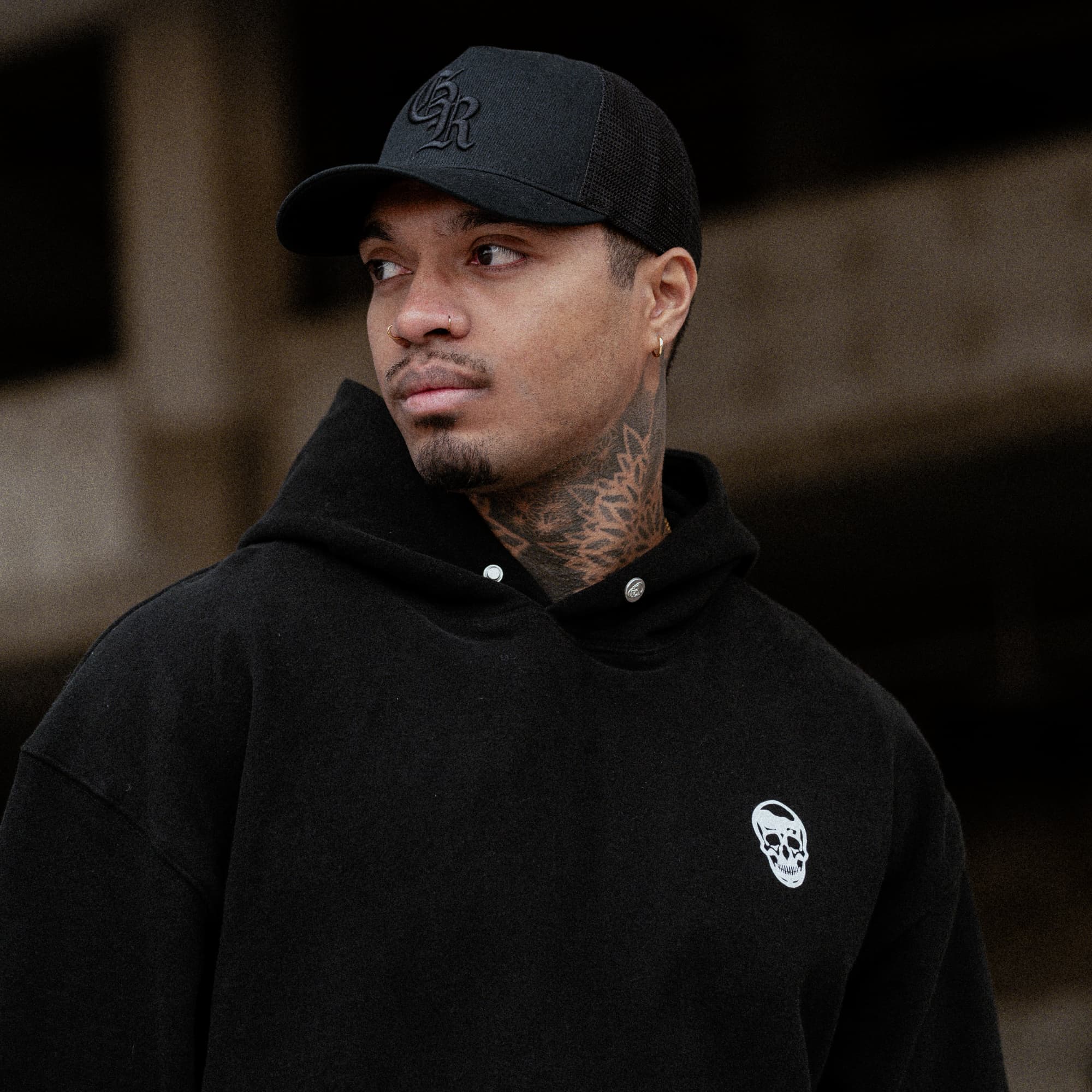 lifestyle shot of athlete wearing the Black/Black Initial Trucker Hat