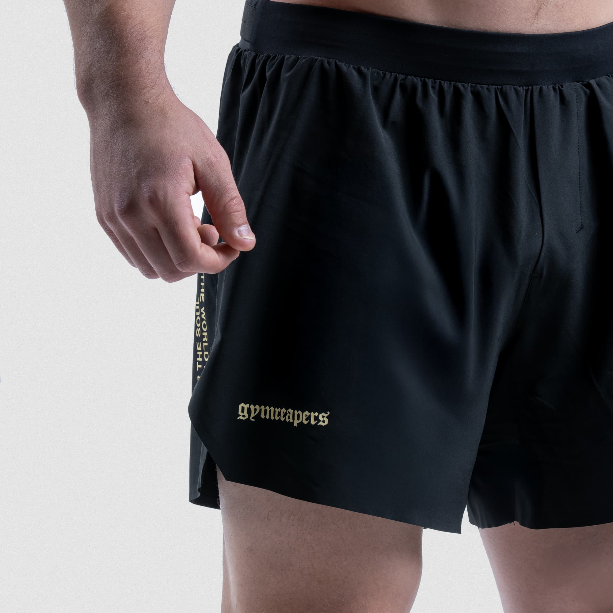 Close-up of Master the Soul running shorts showing quote detail, side slit, and logo at hem