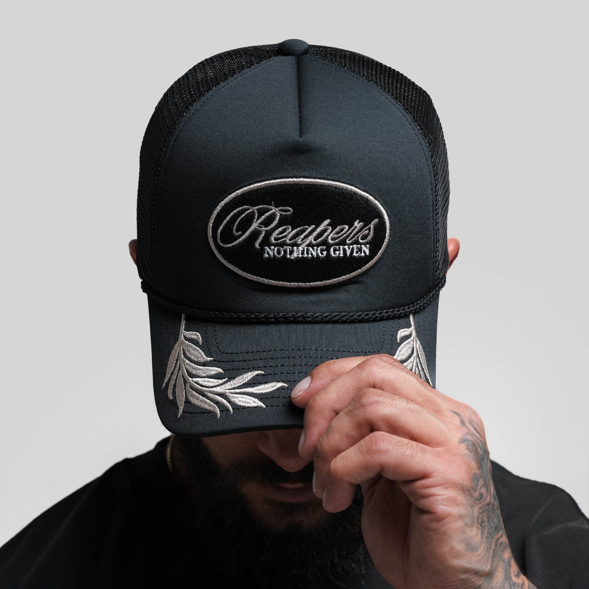 Athlete wearing Laurel Foam Trucker Hat - Black front view looking down to showcase logo