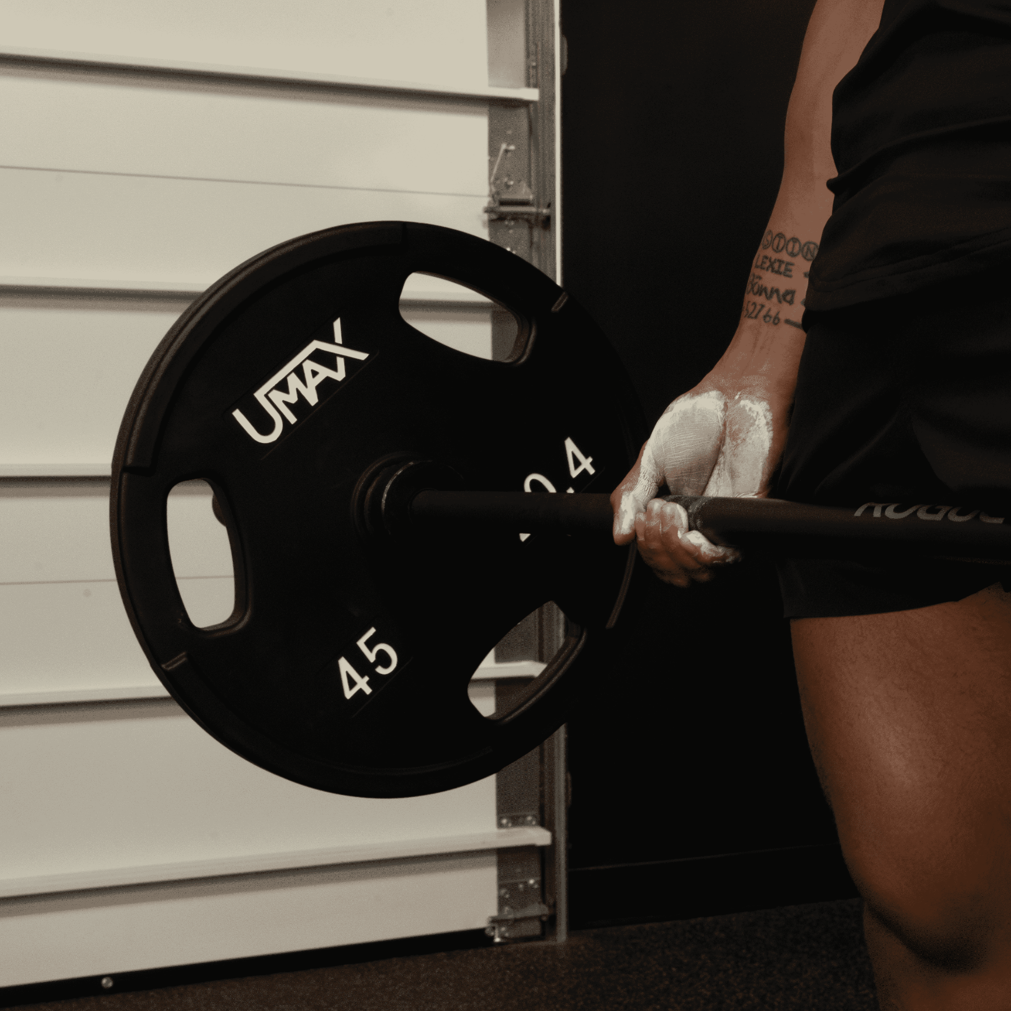 deadlifting with chalk on hands, close up of right side.