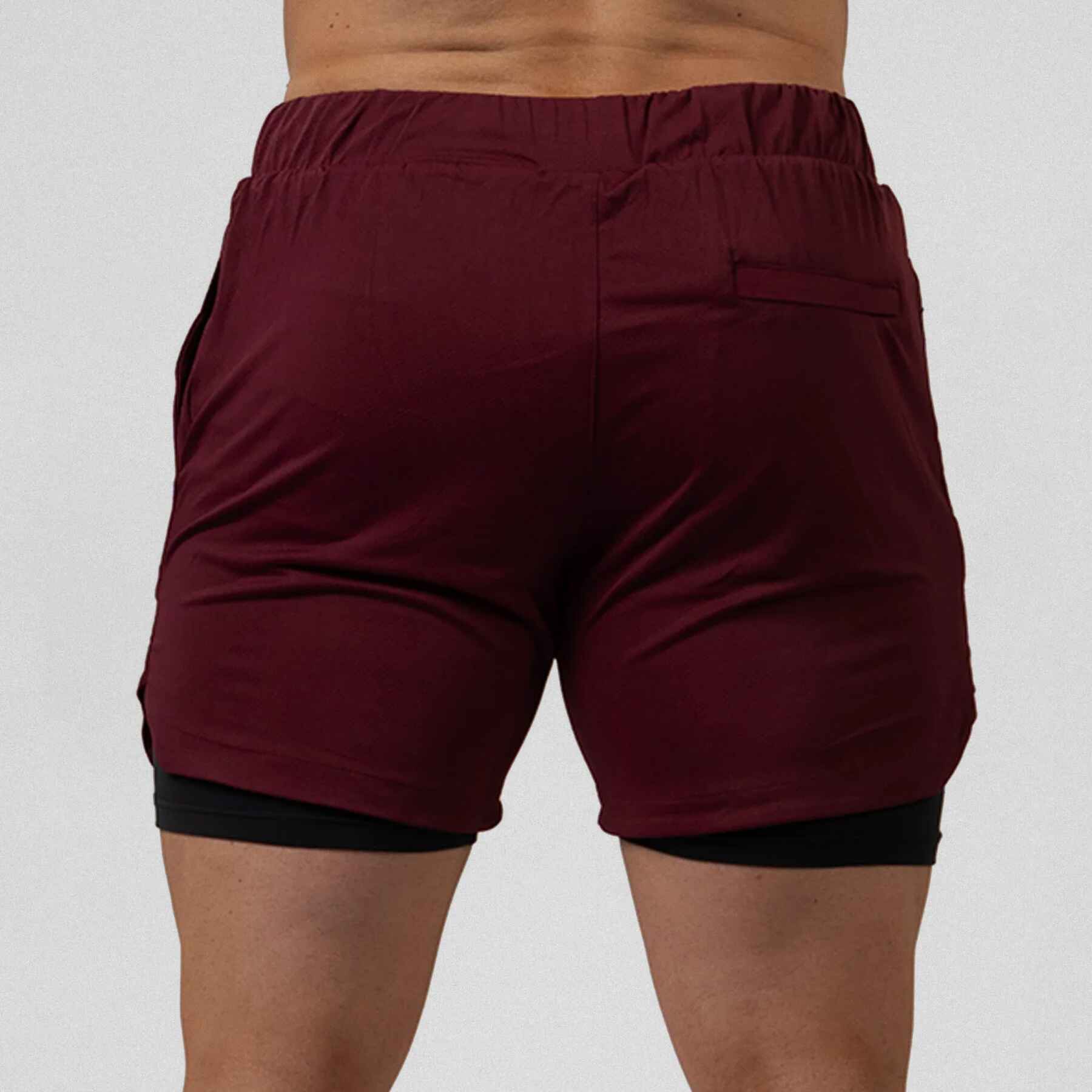 Gymreapers React training shorts maroon color way on athlete showcasing the back of the shorts.
