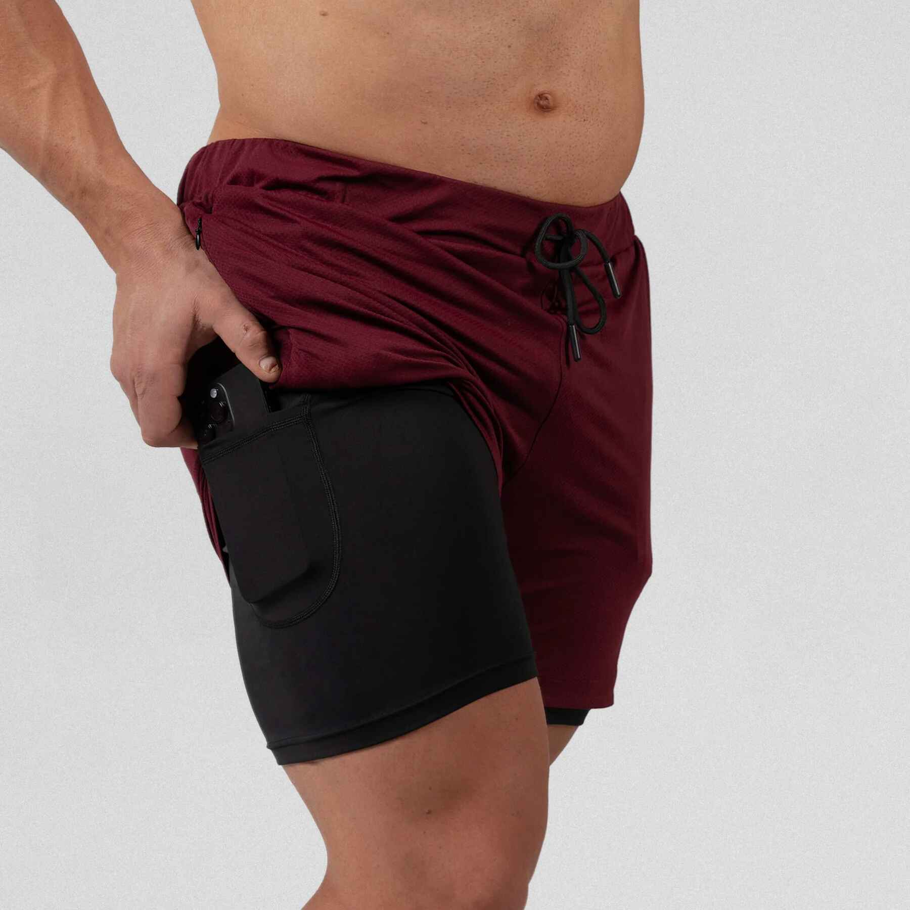 Gymreapers react training shorts maroon with athlete wearing them, zoomed in to hidden pocket side on liner.