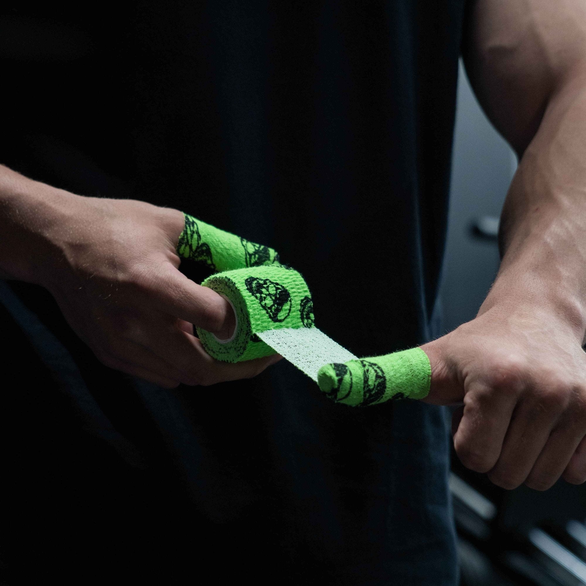 skull tape green being wrapped on thumb